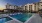 The pool area at our senior living community in Sugar Land, TX, featuring lounge chairs, umbrellas, and tables.