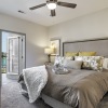 Model bedroom at our active adult community in Sugar Land, TX, featuring carpeted flooring and grey bedspread.