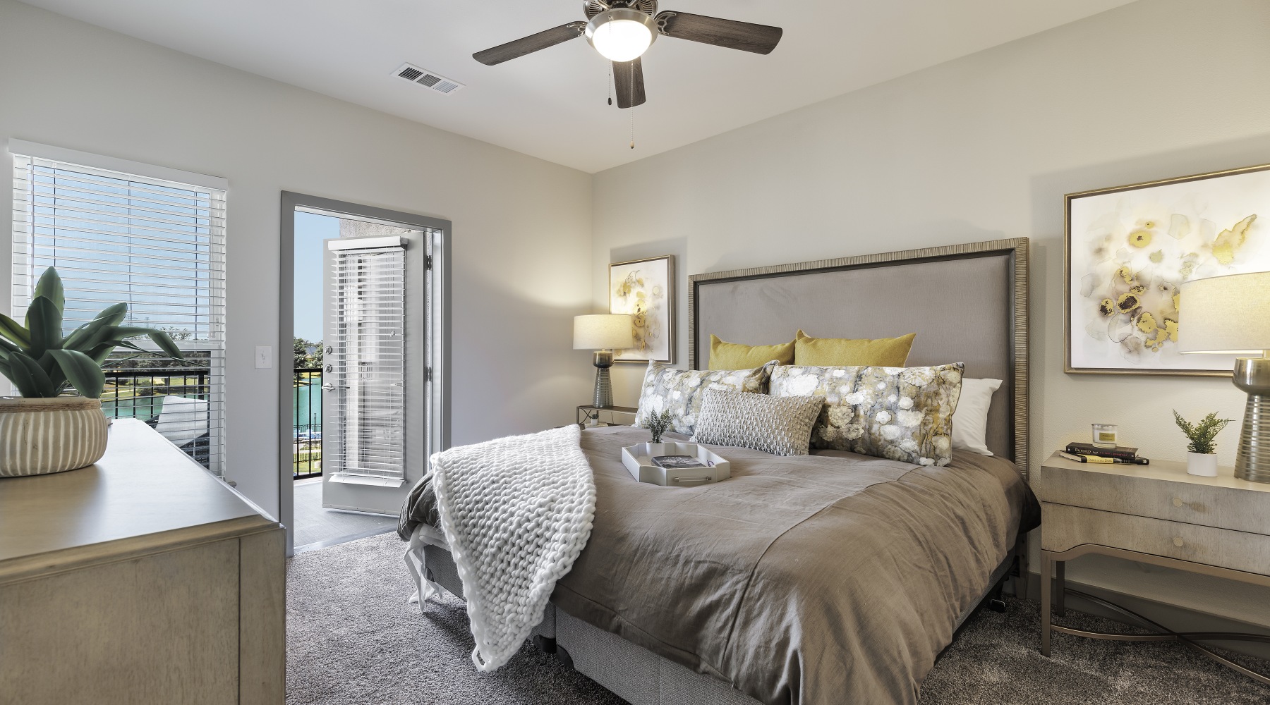 Model bedroom at our active adult community in Sugar Land, TX, featuring carpeted flooring and grey bedspread.