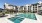 The pool area at our senior living community in Sugar Land, TX, featuring lounge chairs, umbrellas, and tables.