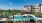 The pool area at our senior living community in Sugar Land, TX, featuring lounge chairs, umbrellas, and tables.